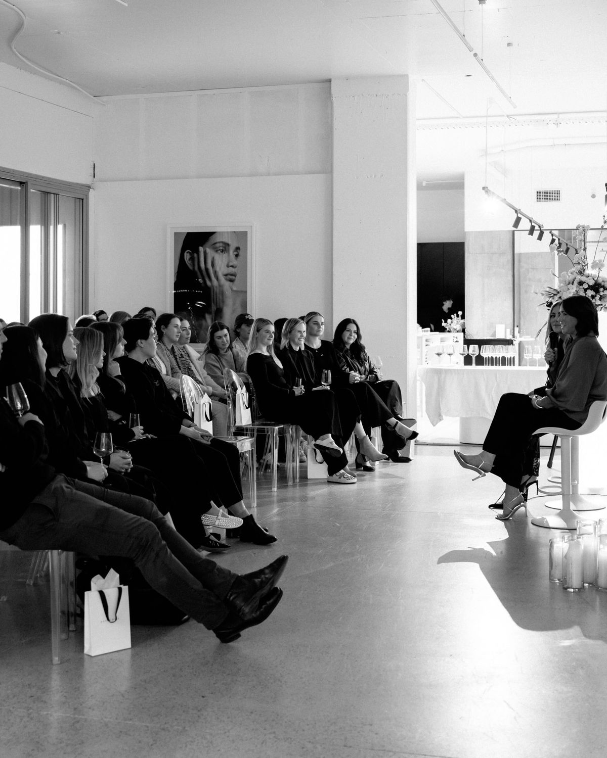 A seated audience in a white studio space